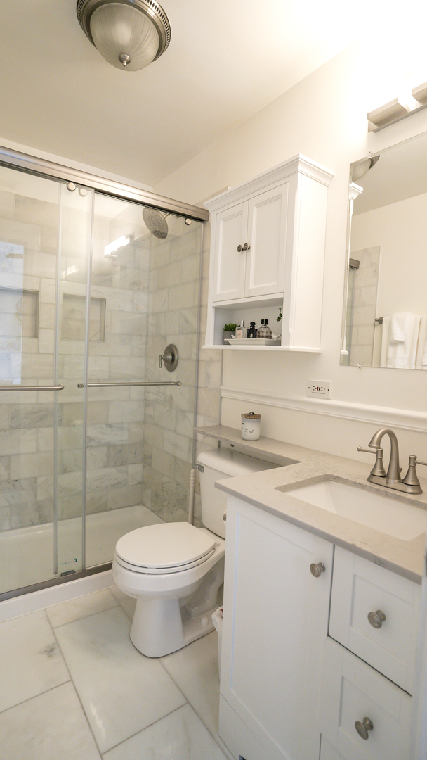 4660 North Spaulding Avenue, Unit 3 Chicago, IL 60625 - Photo 20 of 29 a bathroom with a granite countertop sink toilet a mirror and shower