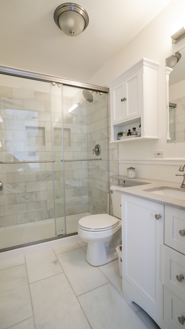 4660 North Spaulding Avenue, Unit 3 Chicago, IL 60625 - Photo 23 of 29 a bathroom with a granite countertop sink a toilet and shower