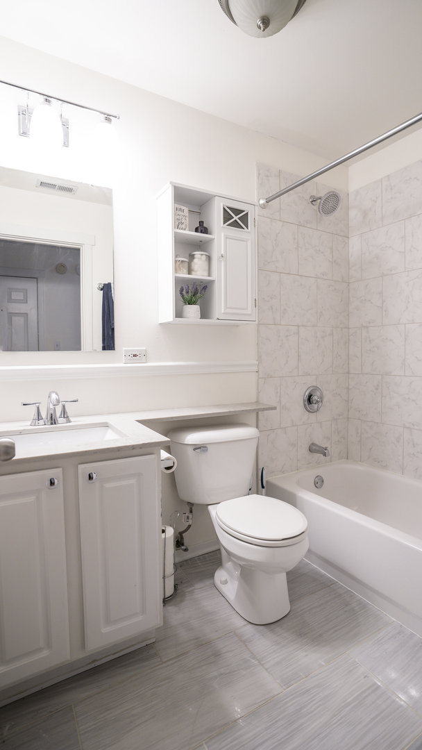 4660 North Spaulding Avenue, Unit 3 Chicago, IL 60625 - Photo 26 of 29 a bathroom with a toilet a sink a mirror and a bathtub