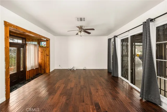 a view of a room with wooden floor and a ceiling fan