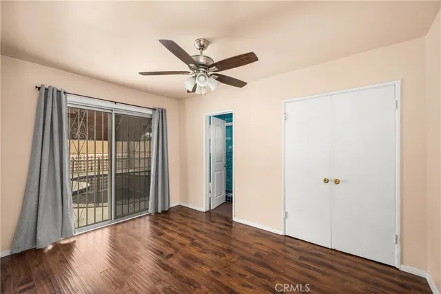 a view of a livingroom with wooden floor and a ceiling fan