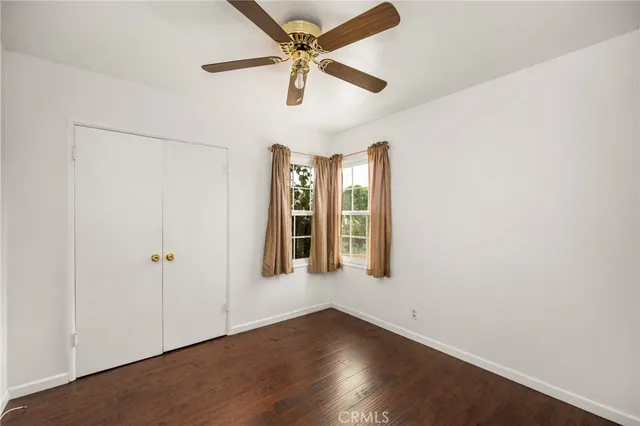 an empty room with fan and windows