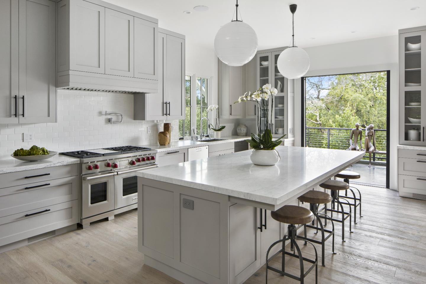 135 Dean Road Woodside, CA 94062 - Photo 8 of 31 a kitchen with stainless steel appliances a dining table chairs stove and white cabinets