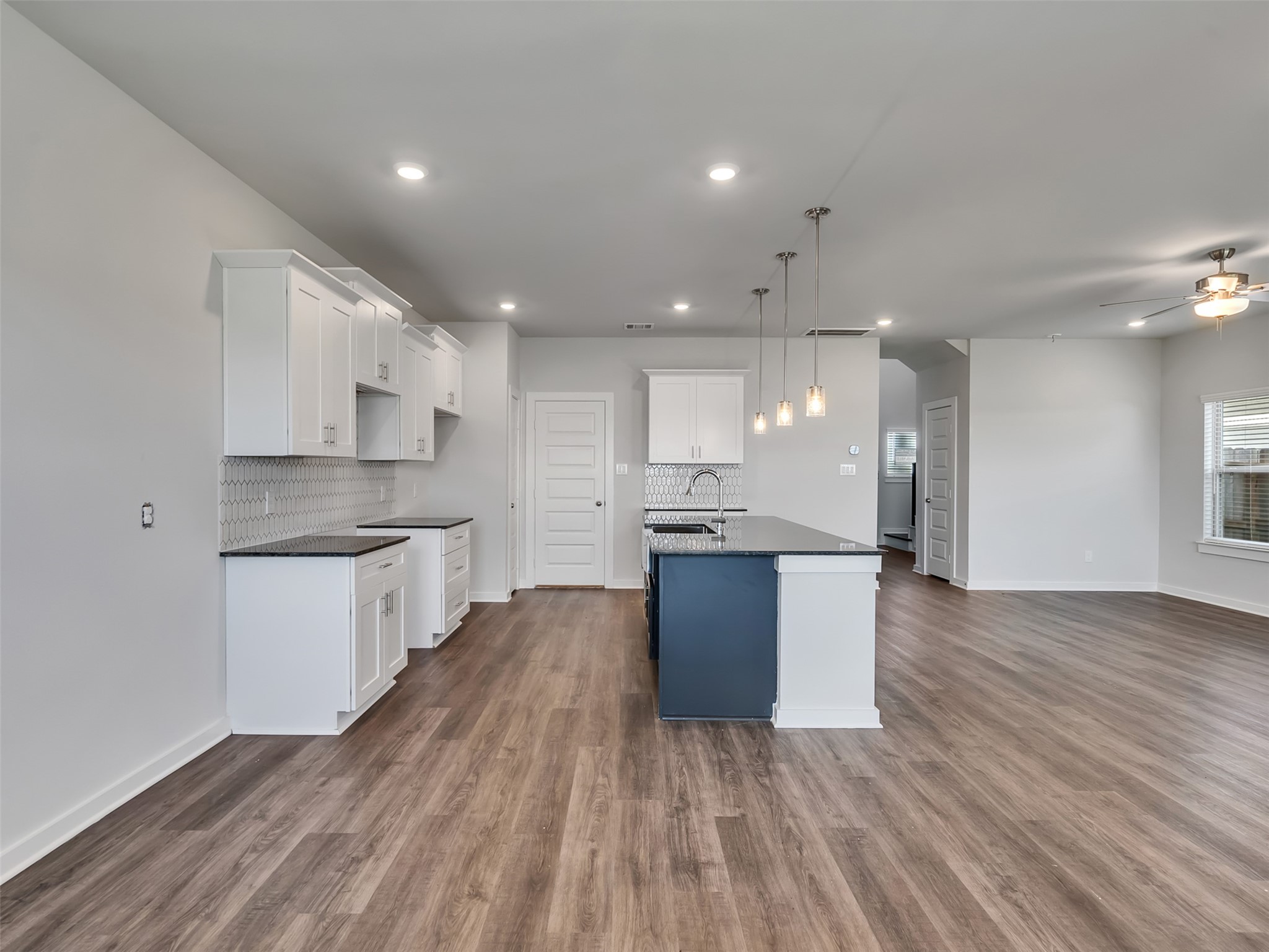 1206 Elsinore Drive Rosharon, TX 77583 - Photo 5 of 21 a large kitchen with kitchen island wooden floors white cabinets and stainless steel appliances