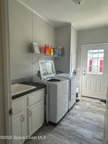 a utility room with cabinets washer and dryer