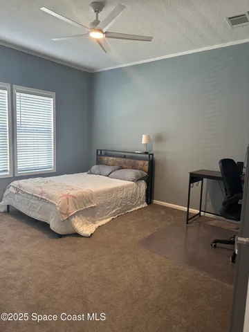 a bedroom with a bed a desk and chair