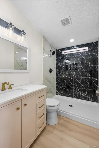 a bathroom with a sink a toilet and shower