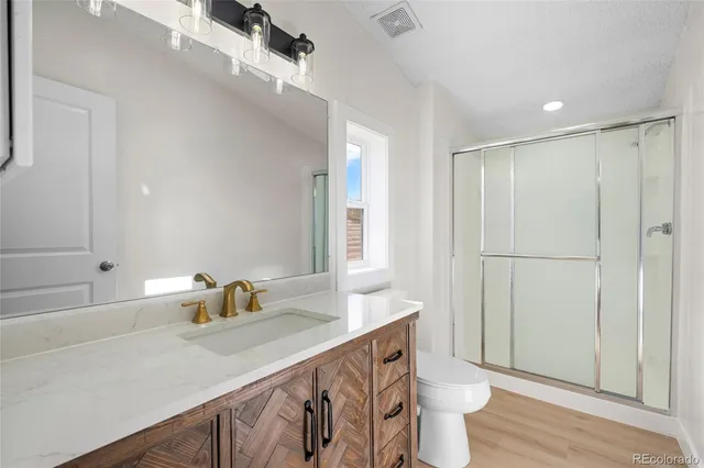 a bathroom with a sink a toilet and shower