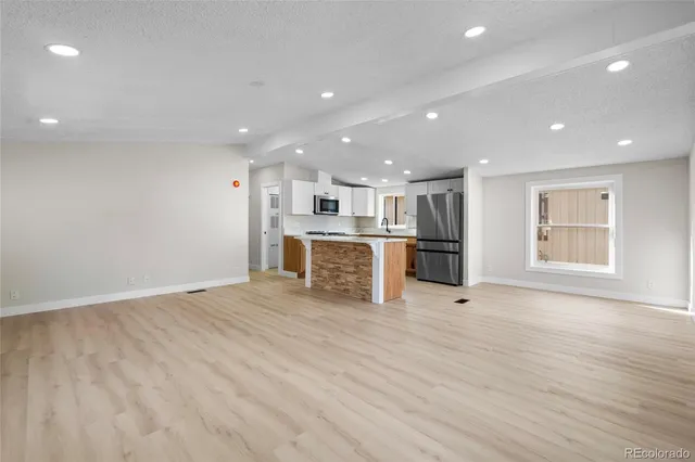 a view of kitchen with refrigerator and window