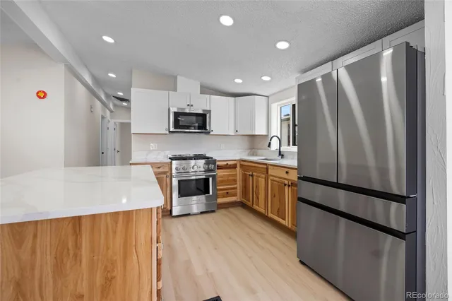 a kitchen with stainless steel appliances a refrigerator sink and microwave