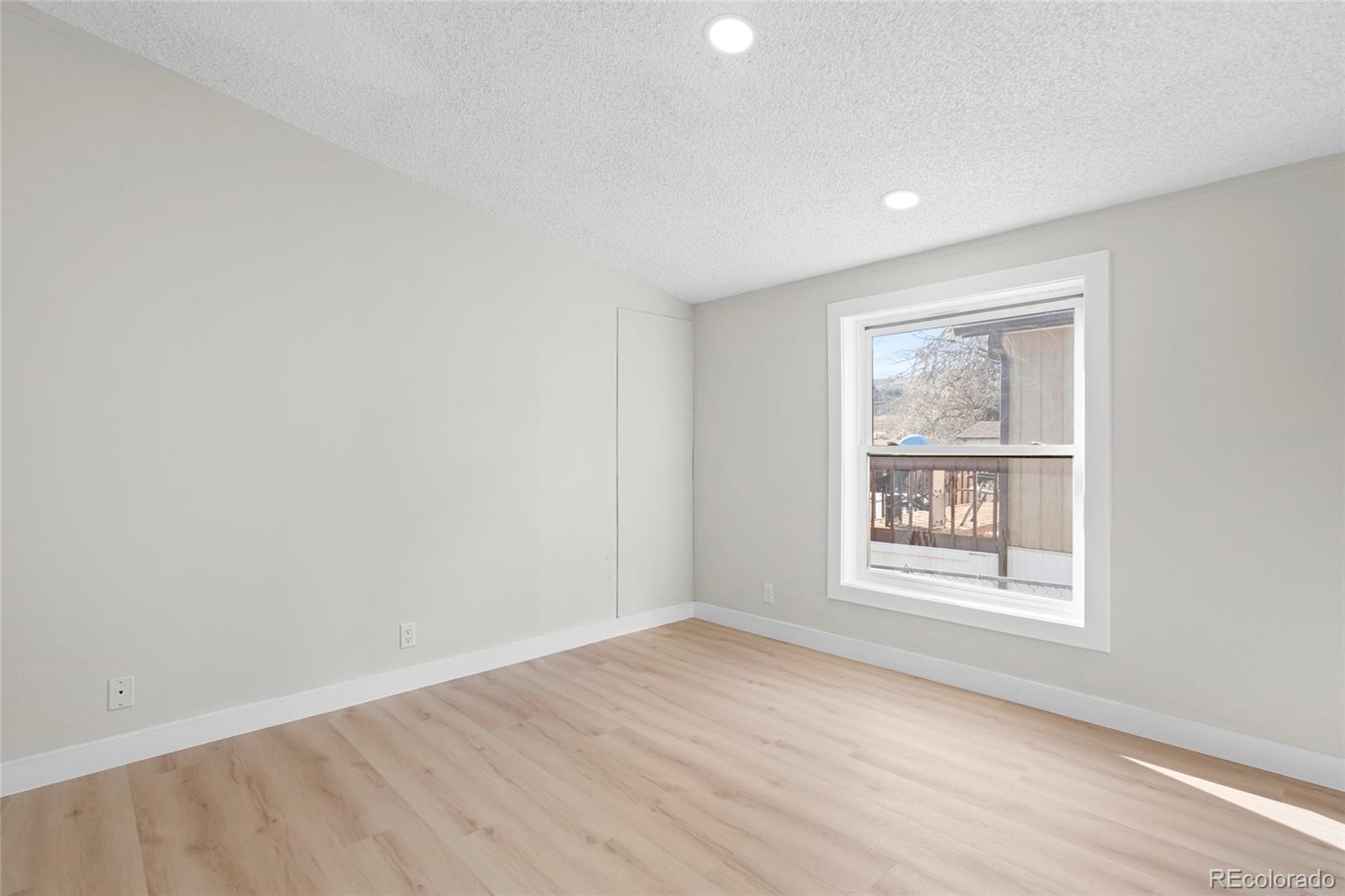 197 Pinto Street Golden, CO 80401 - Photo 10 of 19 an empty room with wooden floor and windows