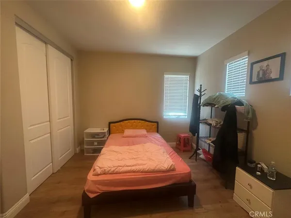 a bedroom with a bed and wooden floor
