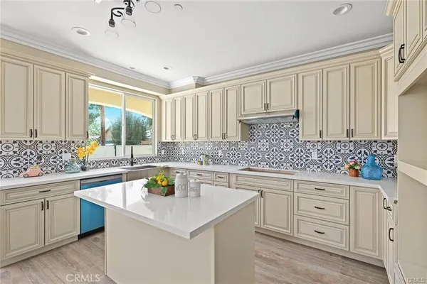 a kitchen with white cabinets sink and stove
