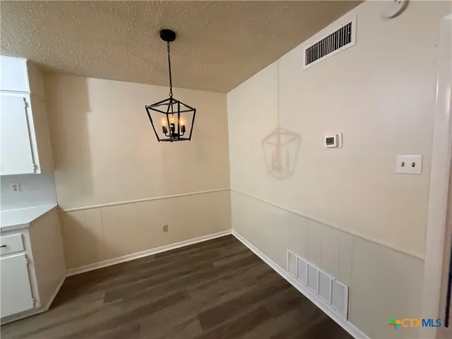 a view of a room with wooden floor and white walls