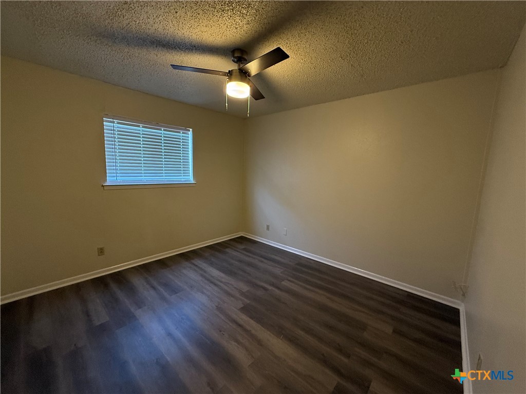 2902 Lake Road, Unit 5 Killeen, TX 76543 - Photo 5 of 5 a view of an empty room with wooden floor and a ceiling fan