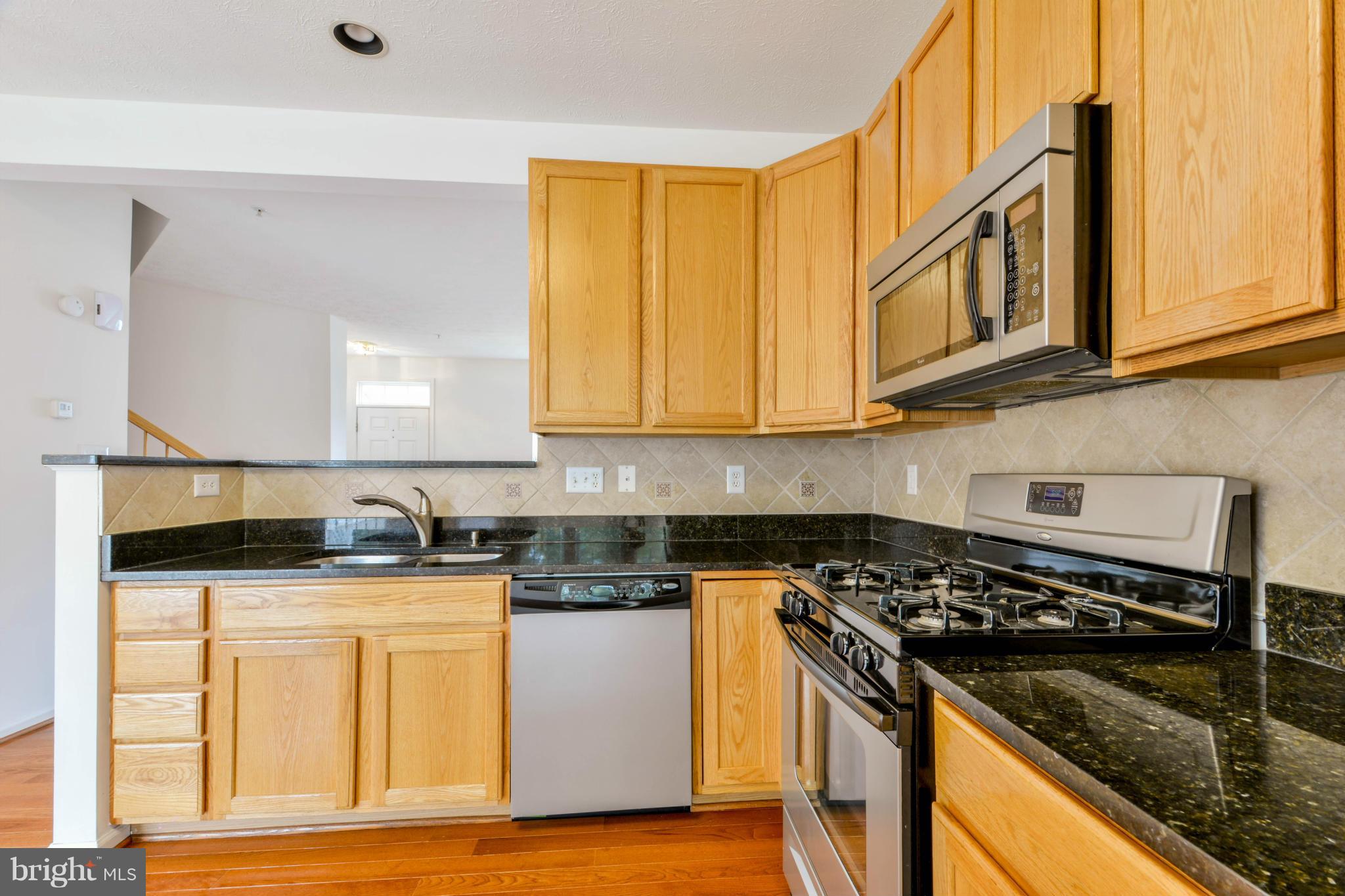 1447 Pangbourne Way Hanover, MD 21076 - Photo 12 of 30 a kitchen with granite countertop a sink a stove and cabinets