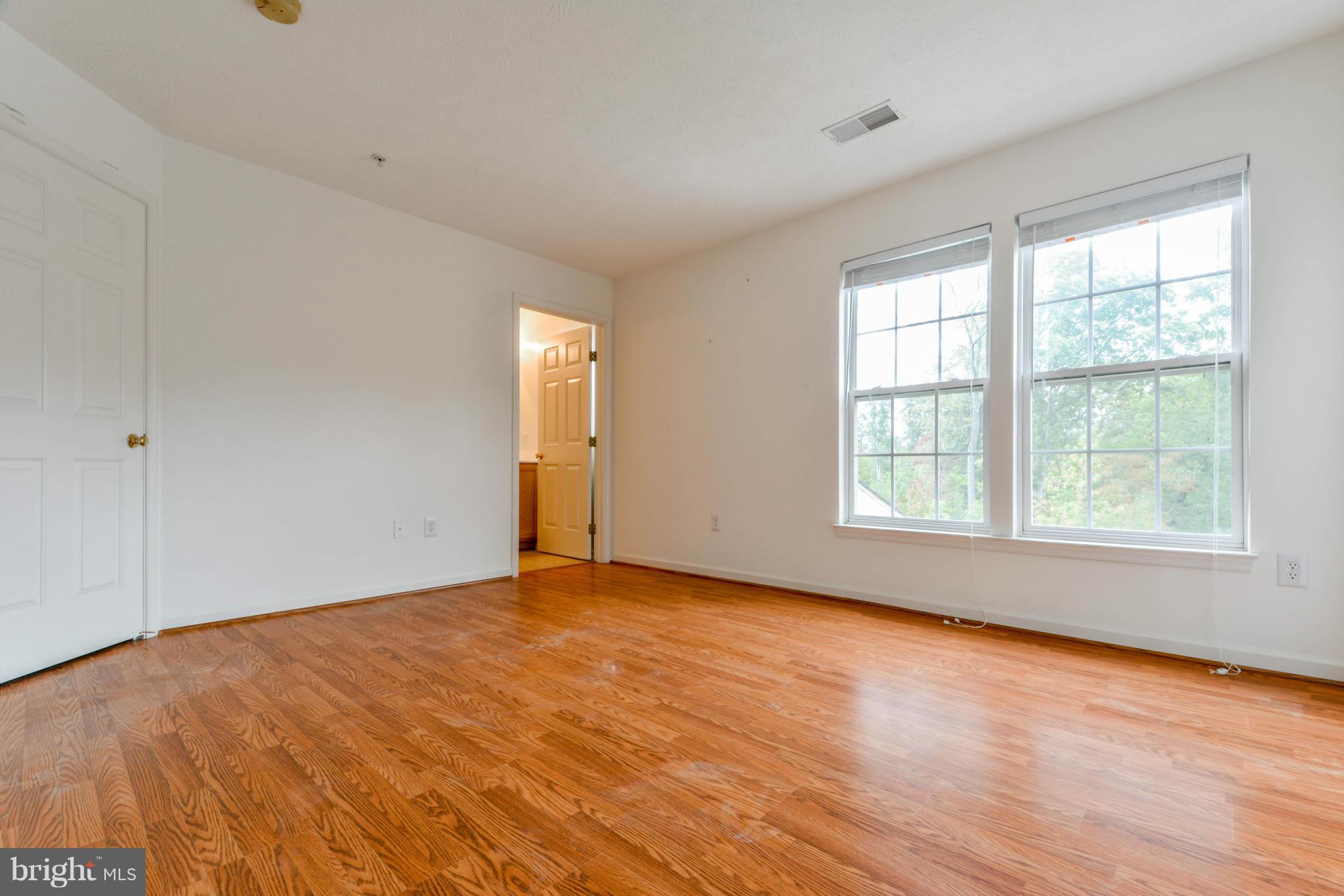 1447 Pangbourne Way Hanover, MD 21076 - Photo 19 of 30 an empty room with wooden floor and windows