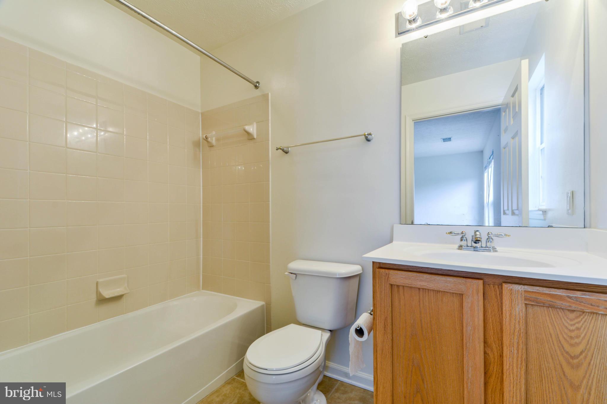 1447 Pangbourne Way Hanover, MD 21076 - Photo 21 of 30 a bathroom with a granite countertop toilet a sink and a bathtub
