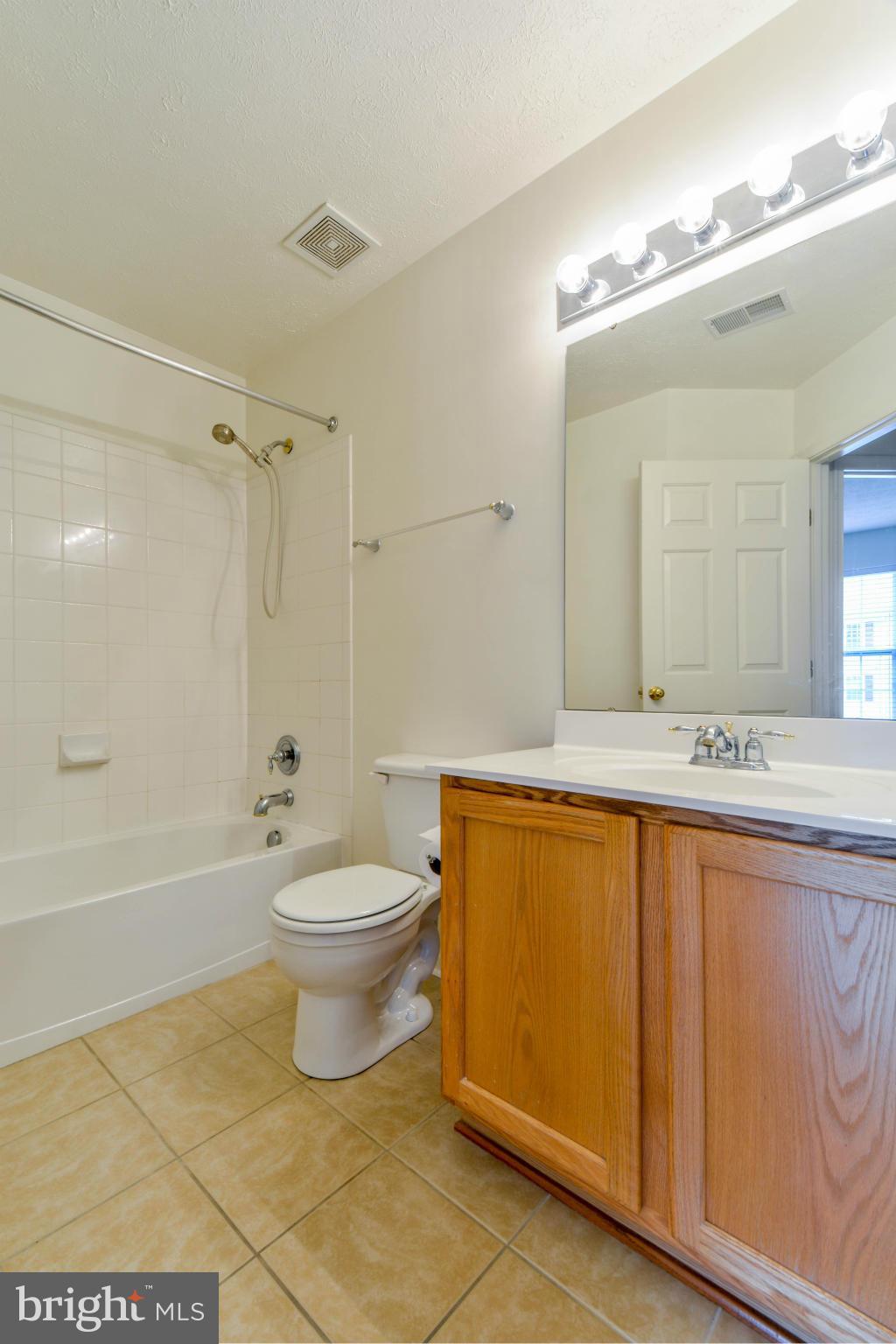 1447 Pangbourne Way Hanover, MD 21076 - Photo 24 of 30 a bathroom with a granite countertop sink toilet mirror and bathtub