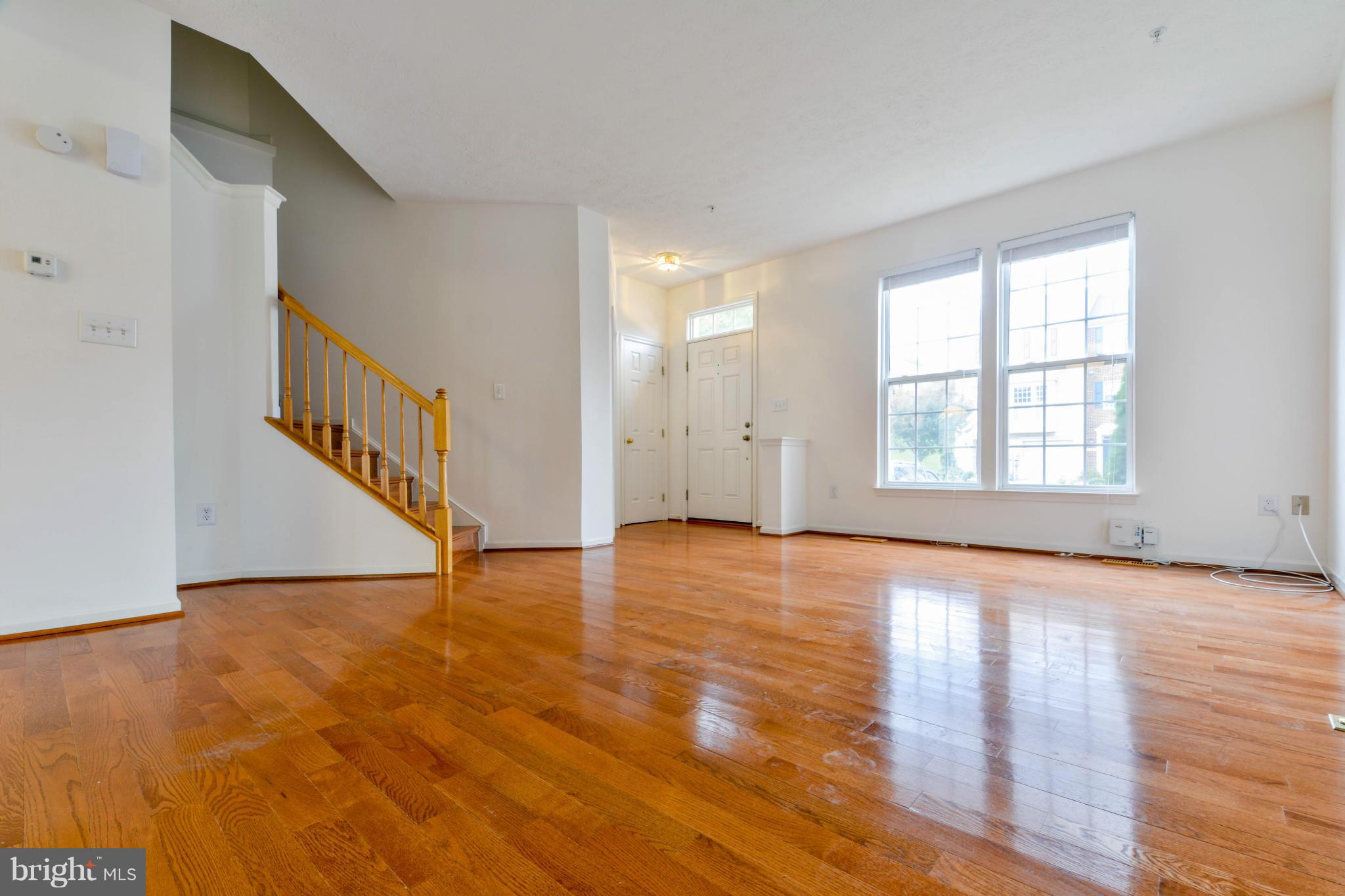 1447 Pangbourne Way Hanover, MD 21076 - Photo 5 of 30 a view of an empty room with wooden floor and a window