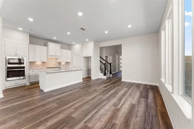 a large kitchen with kitchen island a stove a refrigerator a sink and a large window