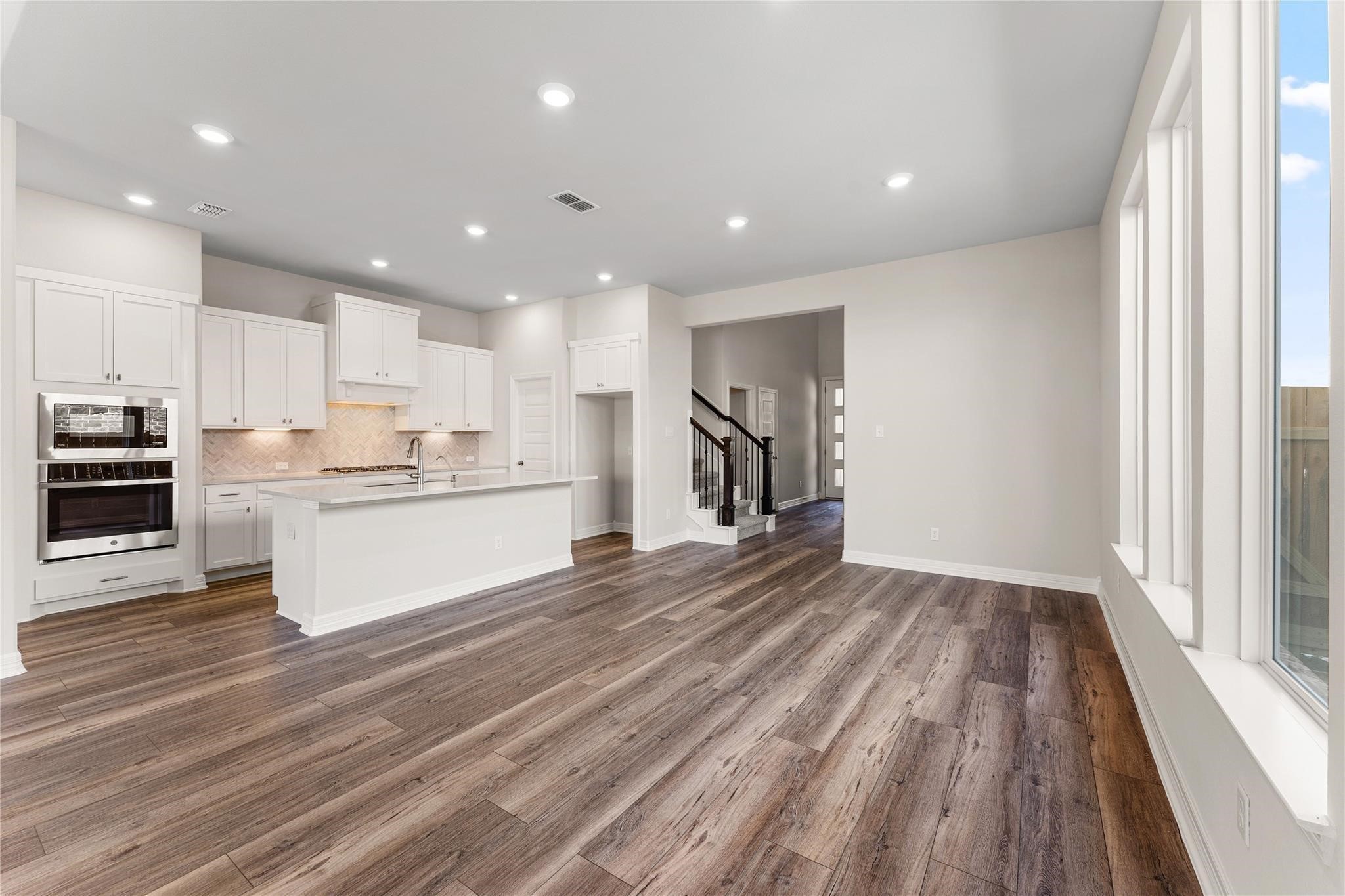 28938 Hauter Way Fulshear, TX 77441 - Photo 11 of 42 a large kitchen with kitchen island a stove a refrigerator a sink and a large window