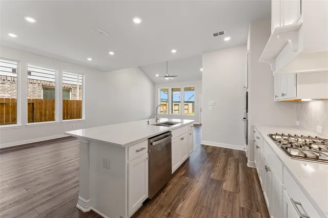 a kitchen with stove and wooden floor