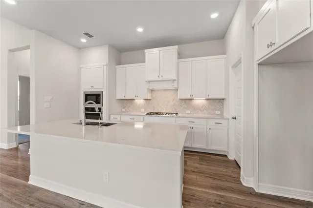 a kitchen with kitchen island white cabinets and refrigerator