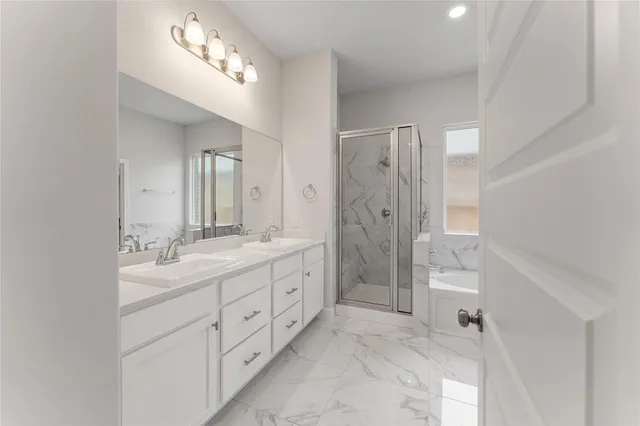 a spacious bathroom with double vanity sink a large mirror a shower and a bathtub