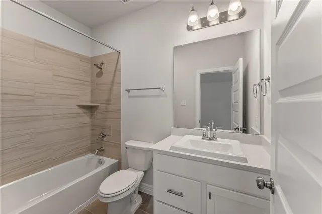 a bathroom with a sink a toilet a mirror a vanity and bathtub