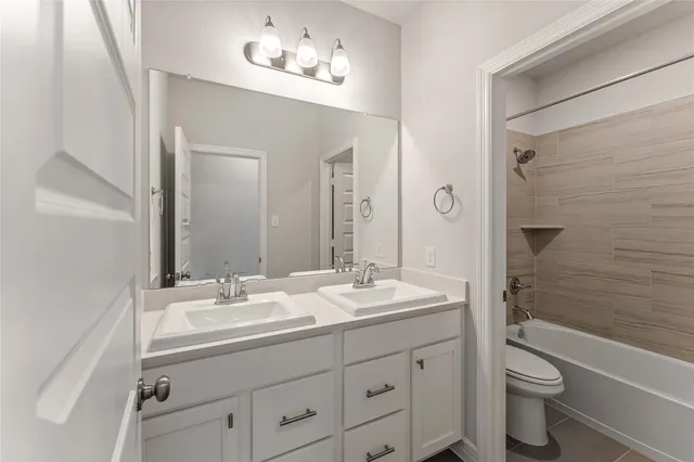 a bathroom with a double vanity sink toilet a shower and a bathtub