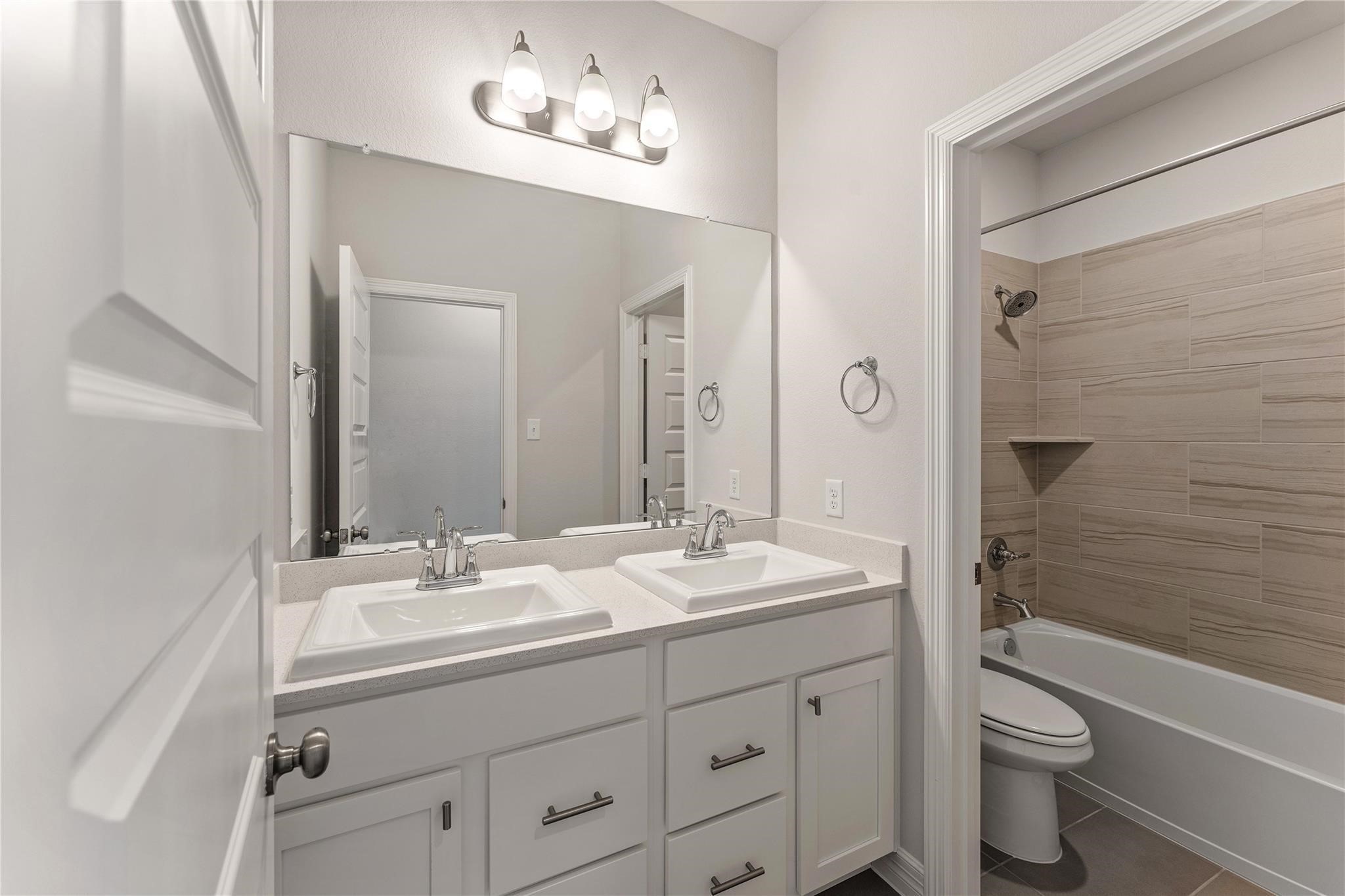 28938 Hauter Way Fulshear, TX 77441 - Photo 36 of 42 a bathroom with a double vanity sink toilet a shower and a bathtub