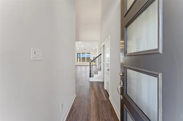 a view of a hallway with wooden floor and staircase