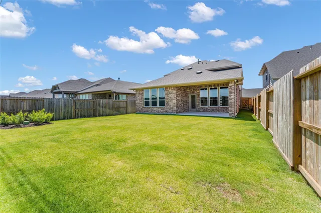 a view of a house with a yard and potted plants