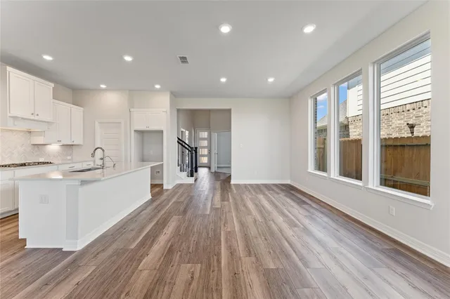 a large kitchen with wooden floor and a window
