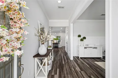 a dining room with chandelier fan and wooden floor