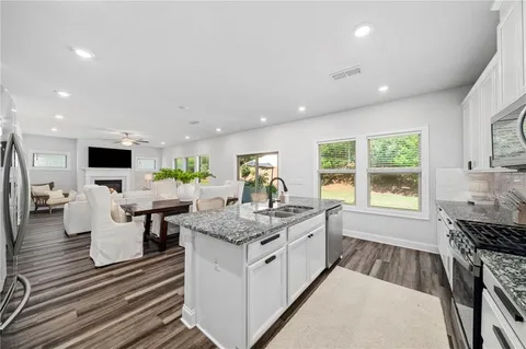 a open kitchen with white cabinets and sink