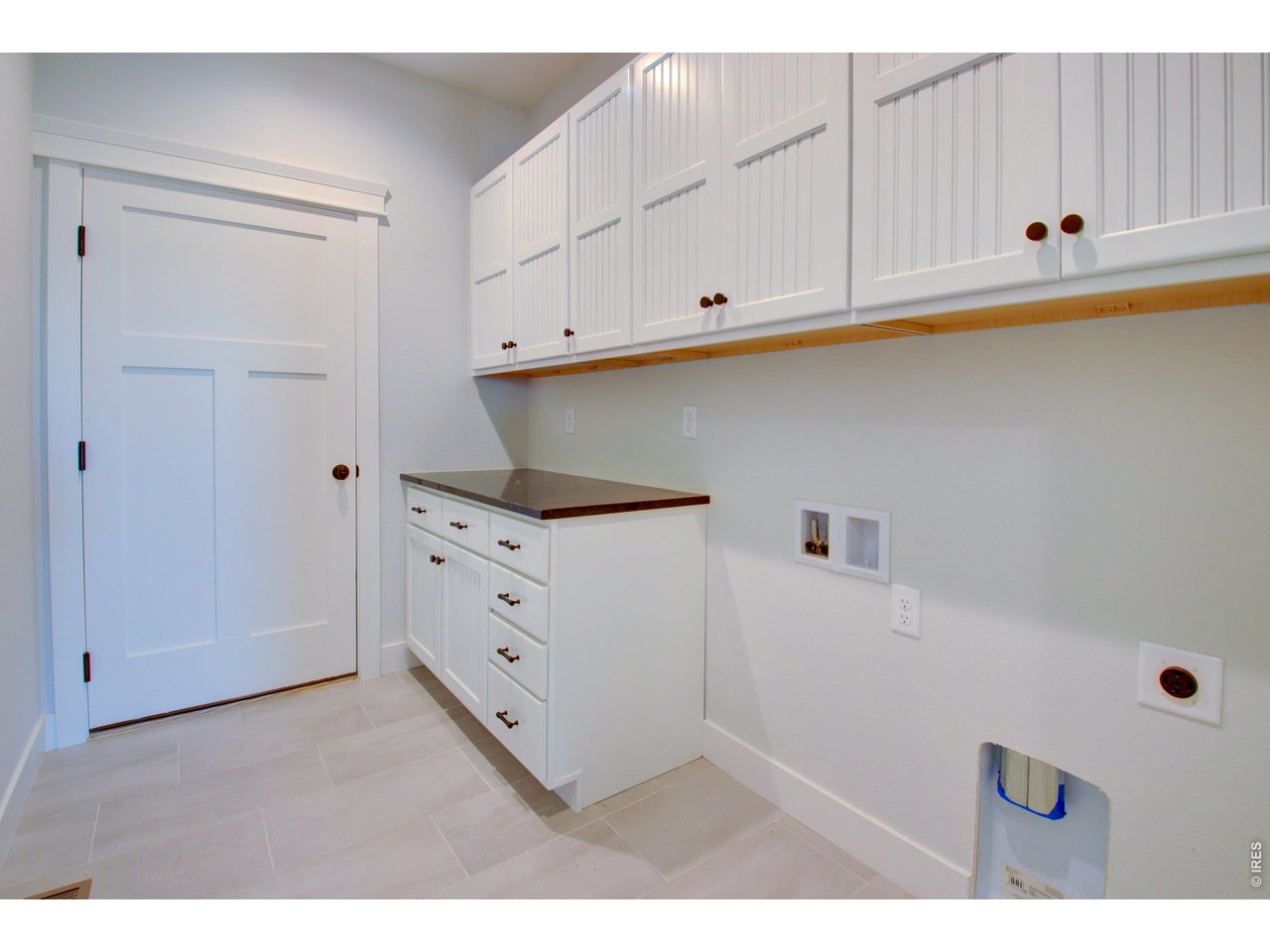 5705 2nd Road Greeley, CO 80634 - Photo 33 of 46 The laundry/mudroom acts as a convenient "drop zone" right off the garage. The washer and dryer are missing from this photo.