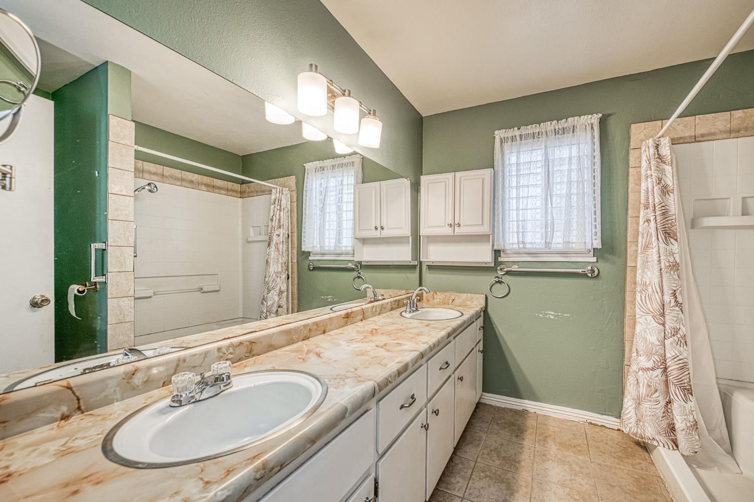 491 West Indianapolis Avenue Clovis, CA 93612 - Photo 22 of 32 a bathroom with a granite countertop double vanity sink a mirror and a shower