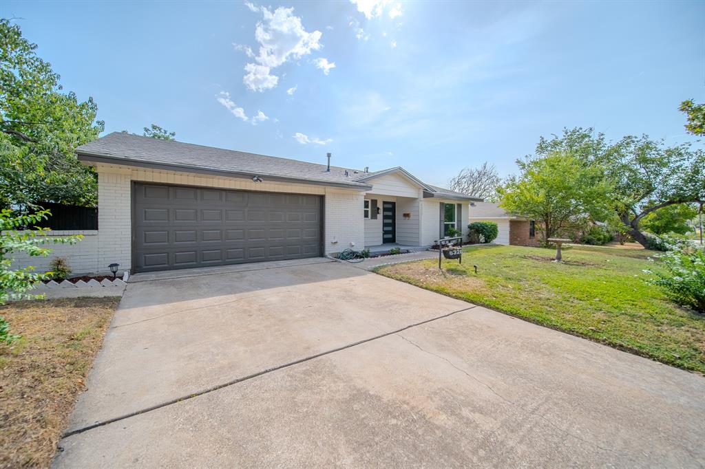 6320 Old Ox Road Dallas, TX 75241 - Photo 2 of 17 Single-story residence featuring a two-car garage, concrete driveway, and a white brick exterior