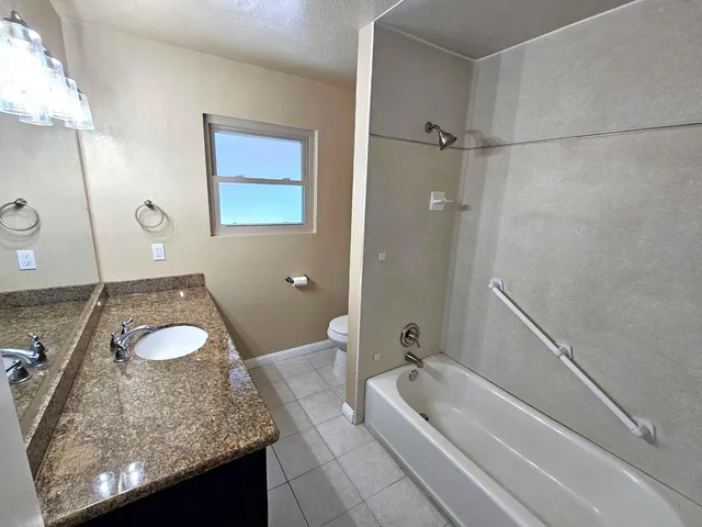 a backyard of a house with barbeque oven and table of chairs