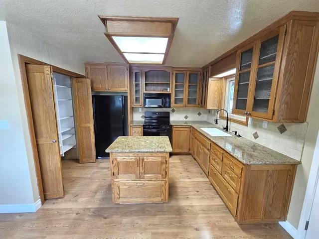 a large kitchen with a stove a refrigerator and a sink