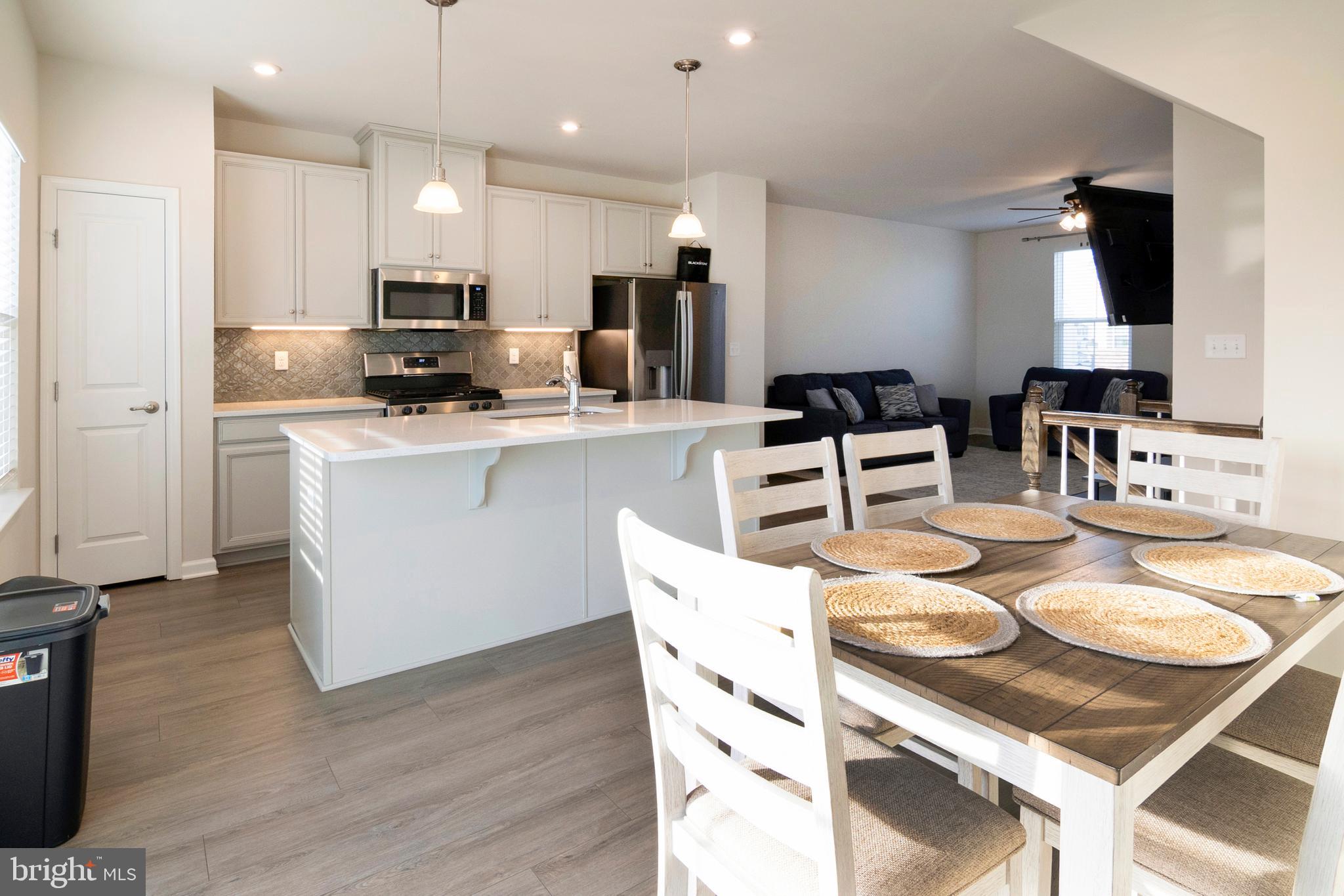 33 Roundstone Run Swedesboro, NJ 08085 - Photo 12 of 43 a kitchen with stainless steel appliances kitchen island granite countertop a sink a stove a dining table and chairs