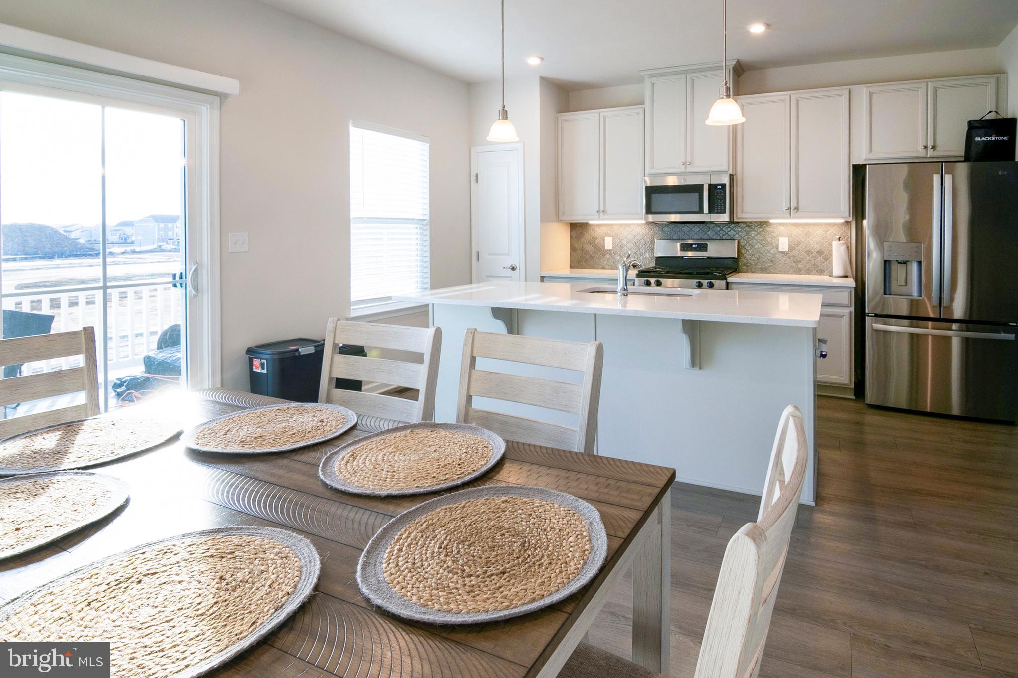 33 Roundstone Run Swedesboro, NJ 08085 - Photo 14 of 43 a kitchen with granite countertop a sink a stove a kitchen island with a dining table and chairs