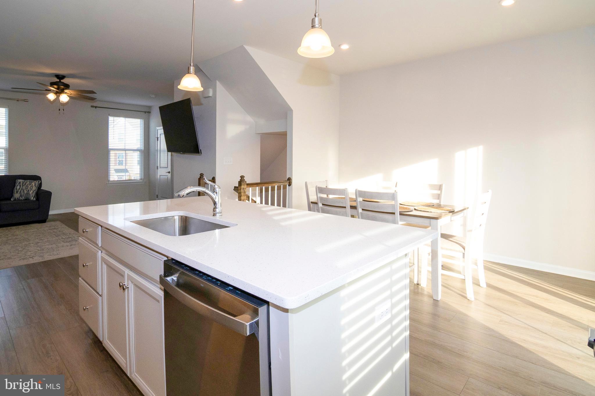 33 Roundstone Run Swedesboro, NJ 08085 - Photo 17 of 43 a kitchen with a sink dishwasher a stove and a refrigerator with wooden floor