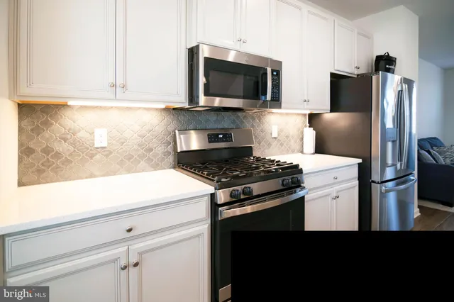 a kitchen with stainless steel appliances a stove microwave and refrigerator