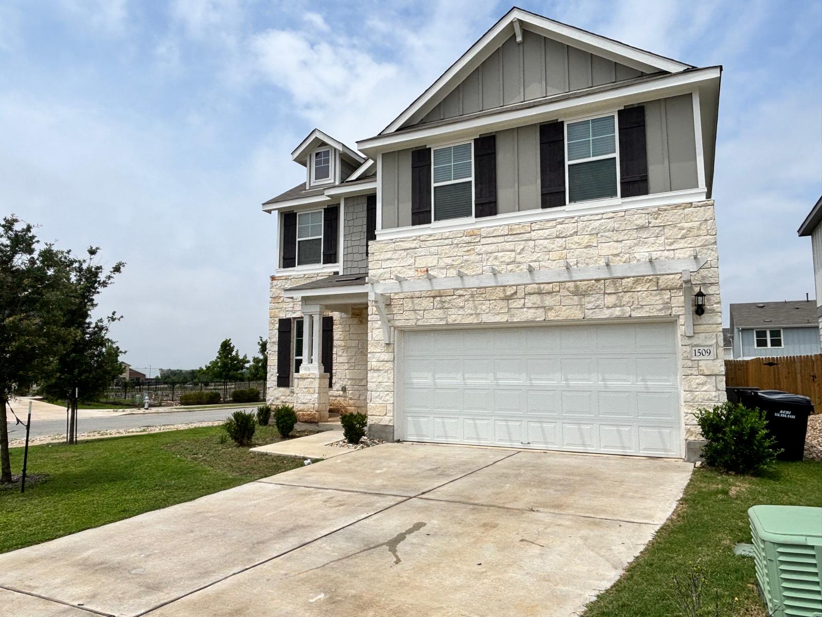 1509 Hope Rnch Road Leander, TX 78641 - Photo 2 of 25 View of front of home with stone siding, concrete driveway, board and batten siding, and an attached garage