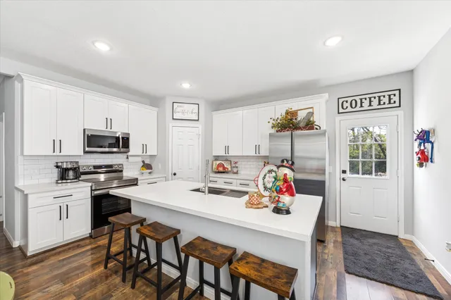 a white kitchen with a table and chairs in it