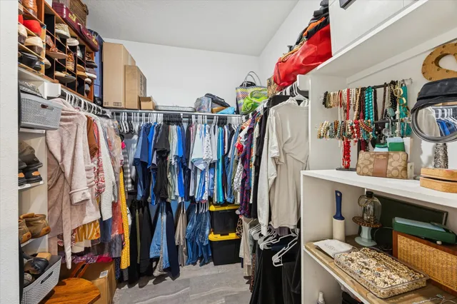 a view of walk in closet with clothes and shoes