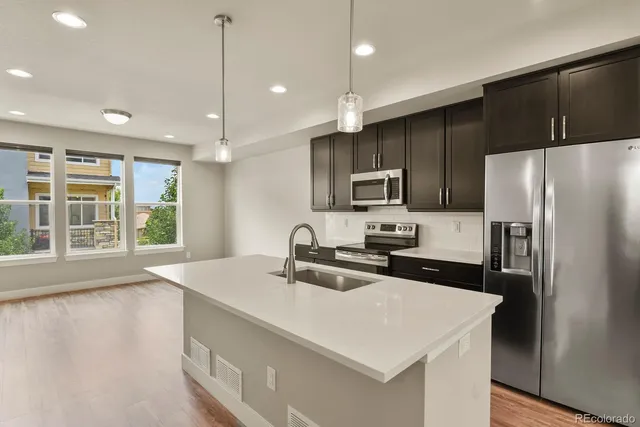 a kitchen with kitchen island a sink appliances and cabinets
